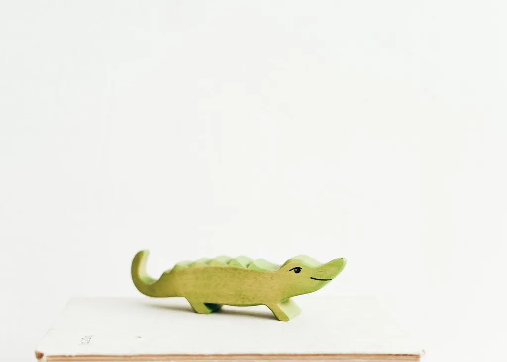 A small green wooden toy crocodile.