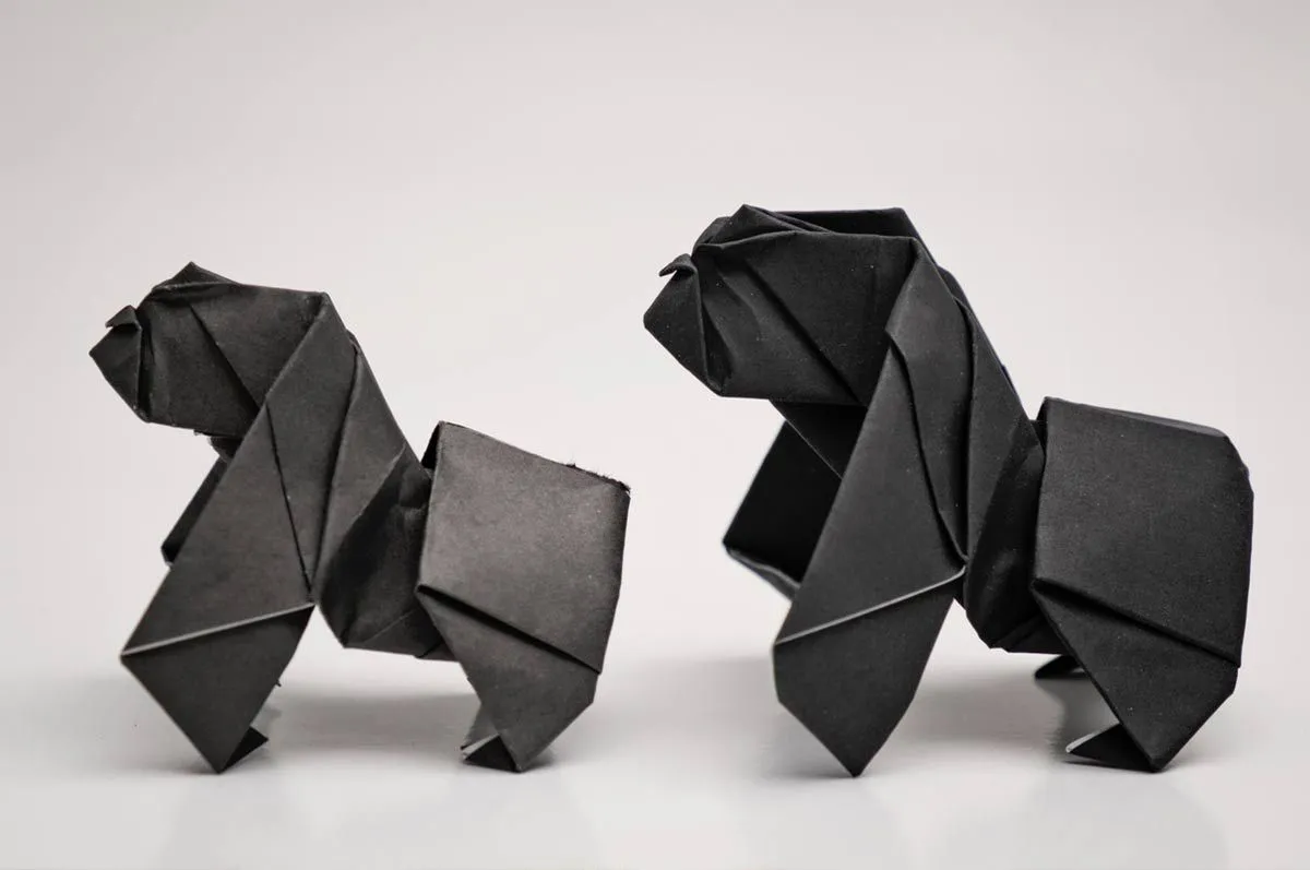 Two origami monkeys standing up side by side. 