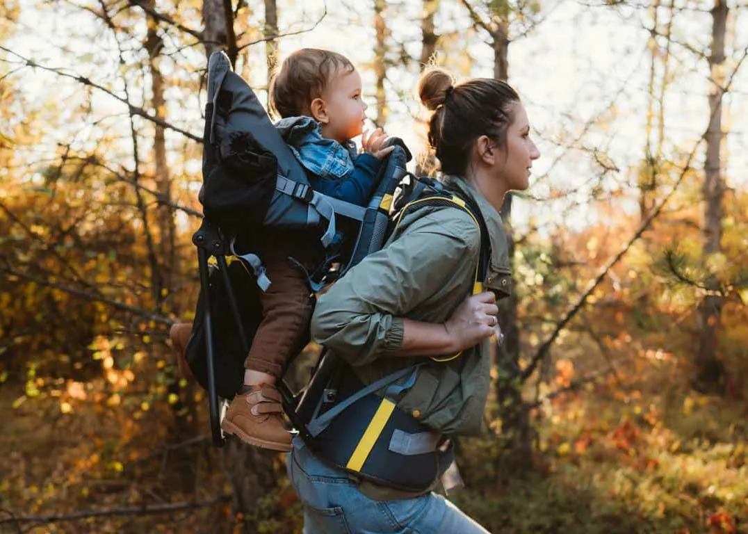 Mother carrying a baby in a baby carrier backpacks