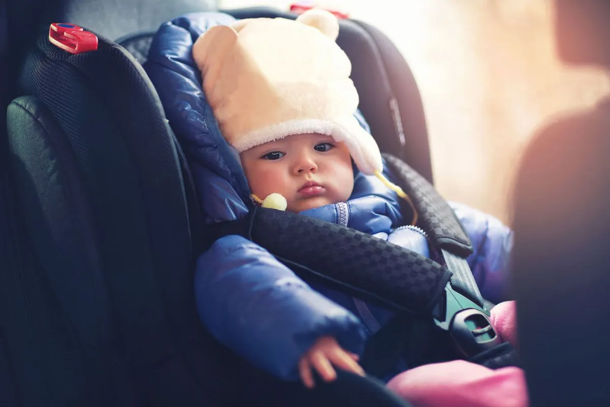 Baby girl sitting in swivel car seat