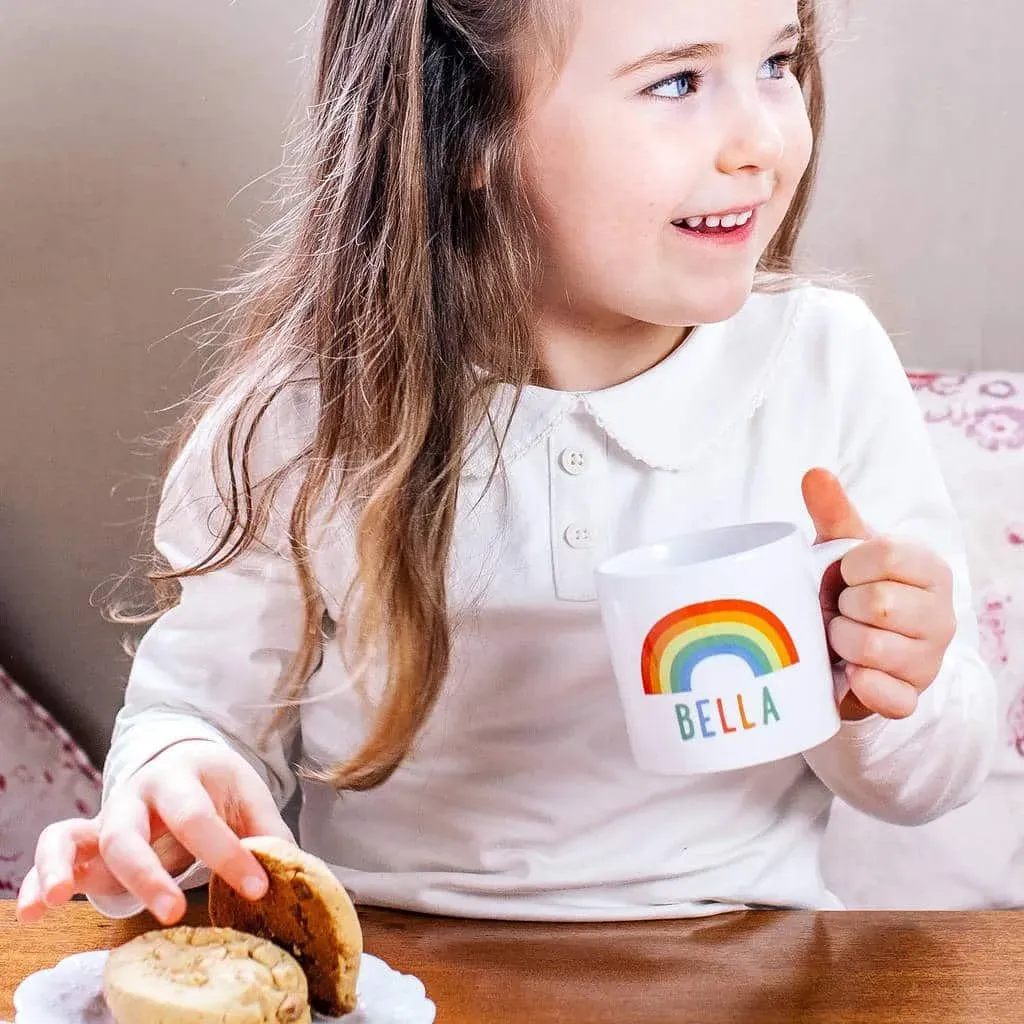 Little girl enjoying her rainbow mug.
