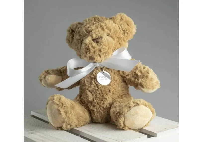 A cuddly personalized Teddy Bear tied with soft white ribbon.