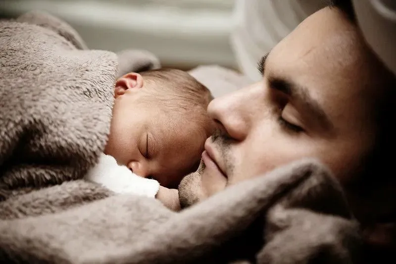Baby sleeping on his father's chest.
