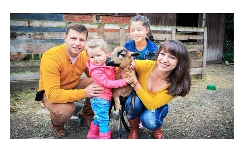 Beautiful family picture holding goat.