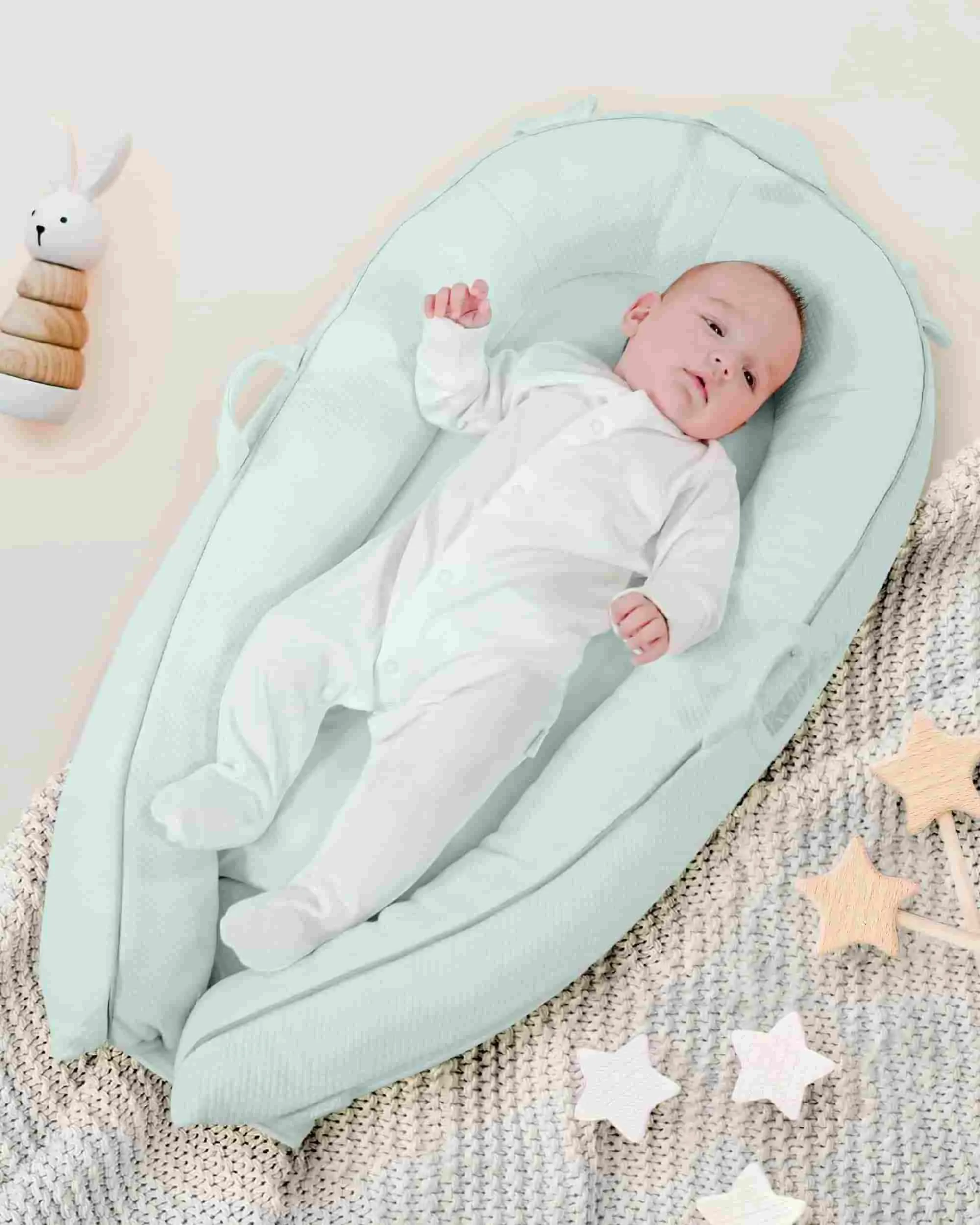 Adorable baby lying down in the smooth blue pod.