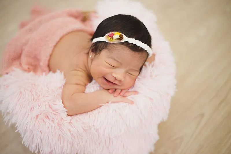 A newborn baby girl sleeping on pink fur