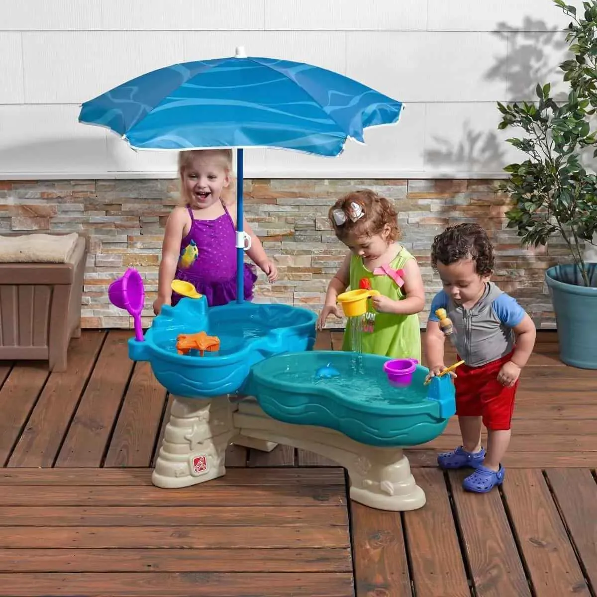 Kids playing spill and splash seaway water table.