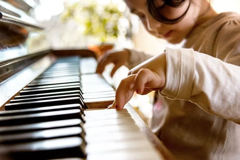A child playing the piano in a music session at home.