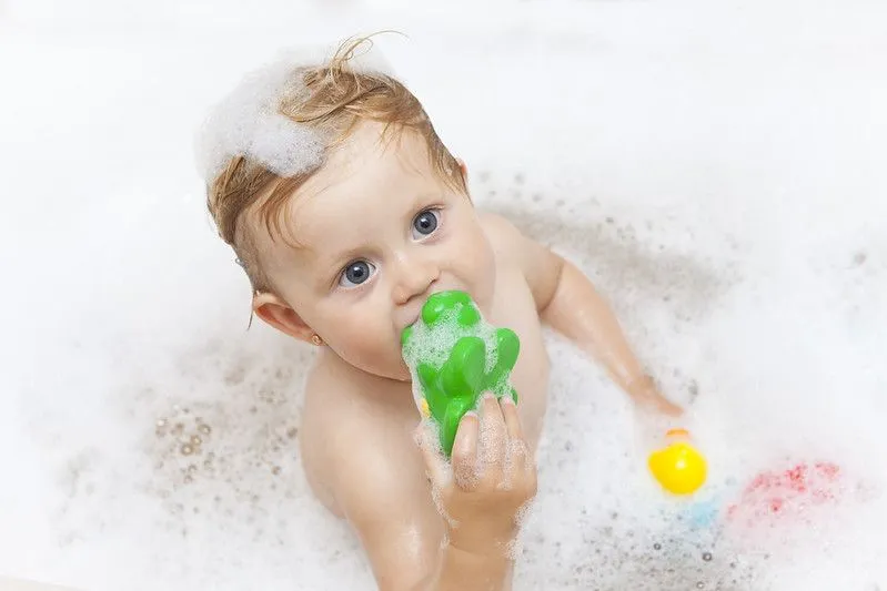 Baby bathing while playing his toy.