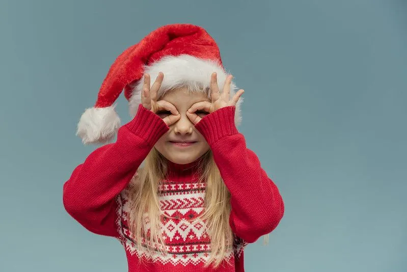 Little girl wearing Christmas Santa hat.