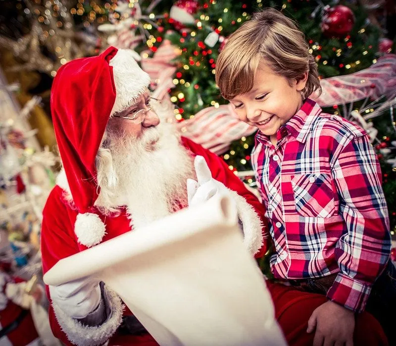 Child telling Santa what toys are at the top of their list.