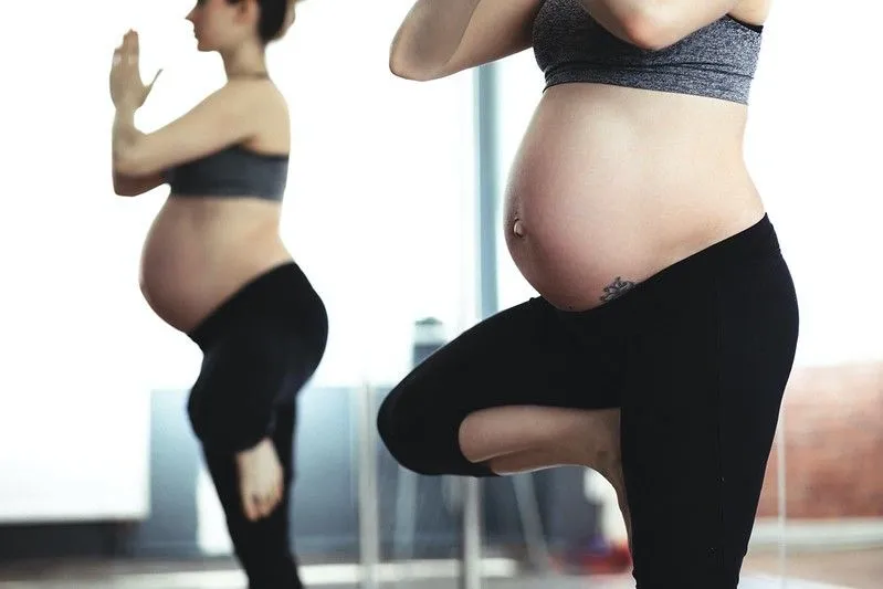 Pregnant woman doing yoga in sportswear. 
