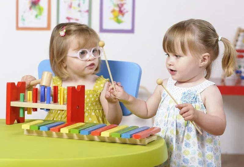 Toddlers playing with musical playset. 