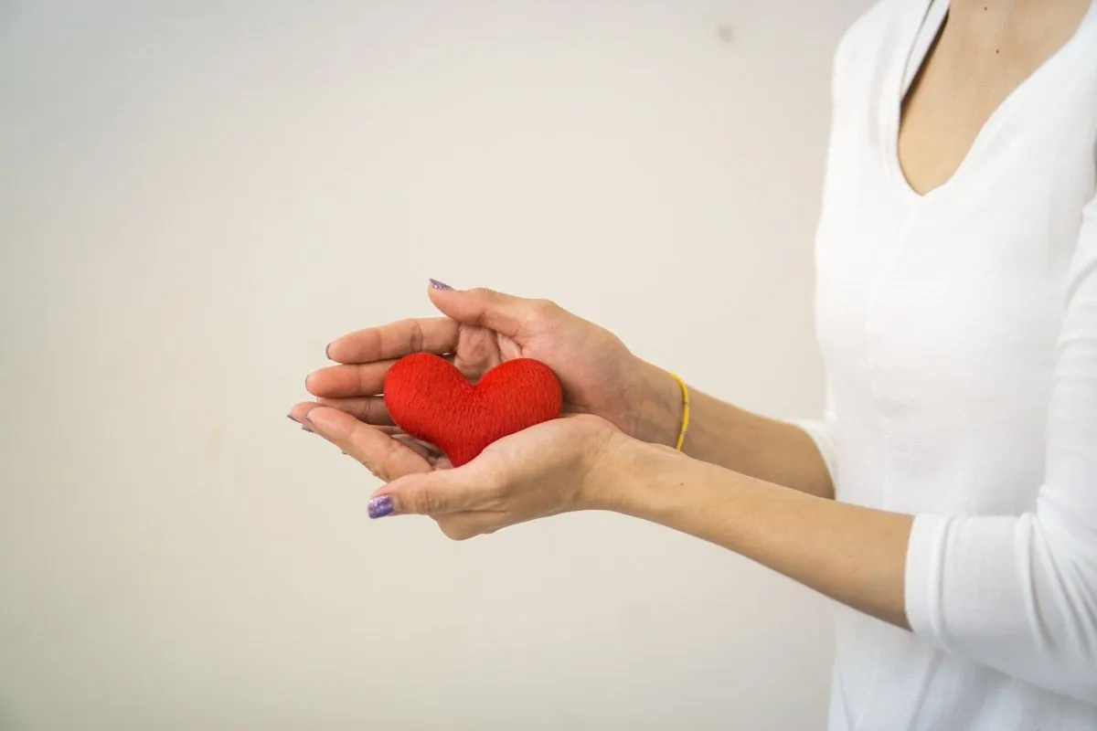 A woman holding a red heart