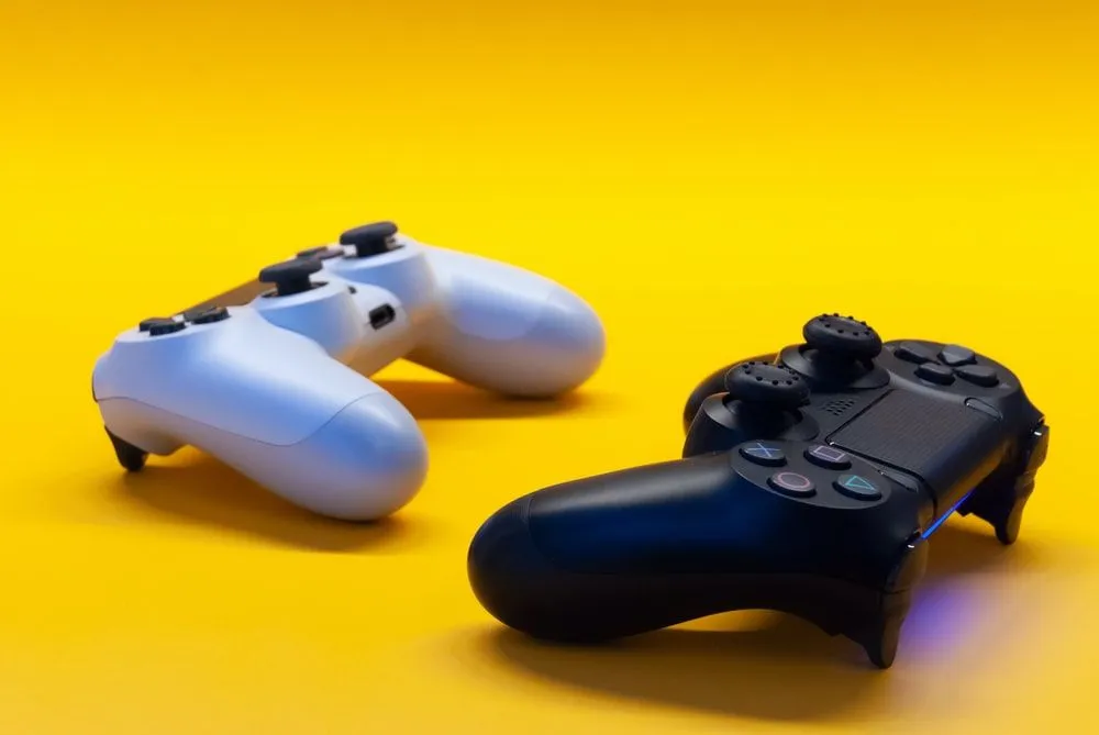 White and black game controller on yellow background