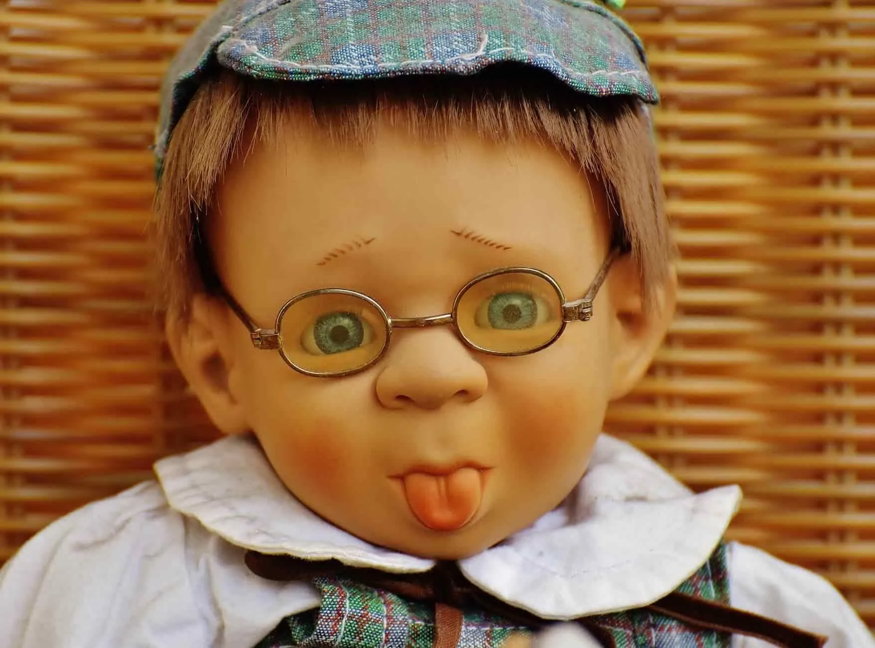 Close up of a doll wearing small glasses with its tongue out - Quotes