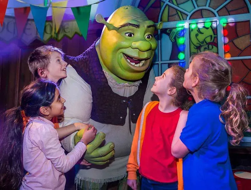 Smiling children meeting Shrek at Shrek's Adventure.