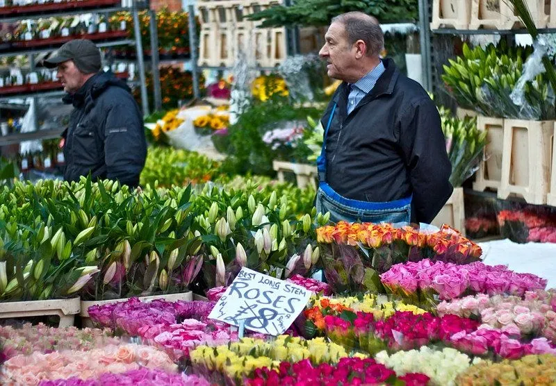 A man standing at his stall at Columbia Road Flower Market.