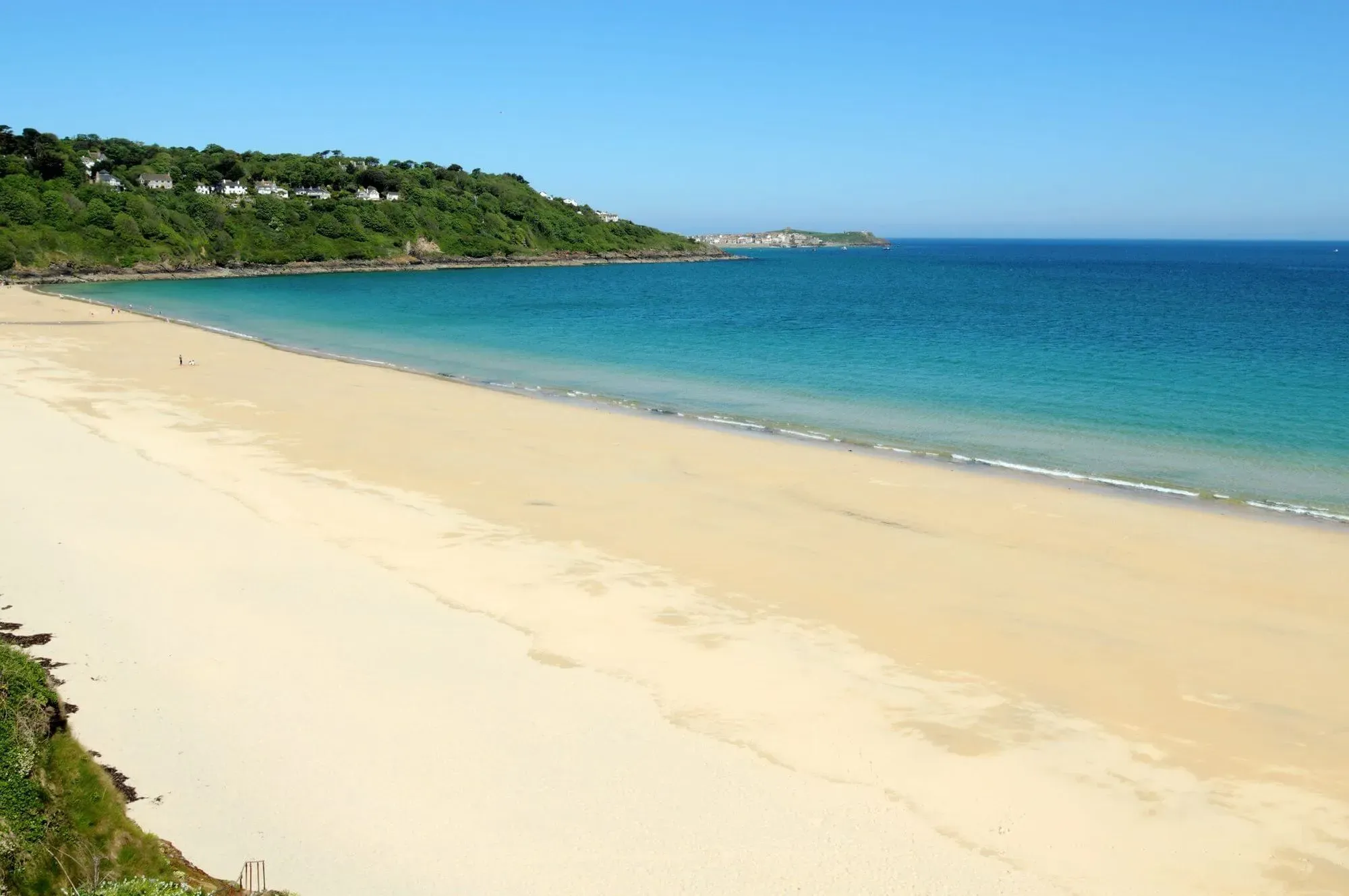 A view of the golden sands at Carbis Bay Beach with blue ocean waves.