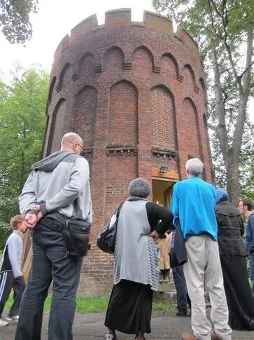 People looking up at the red brick Tudor Tower at Bruce Castle Museum.