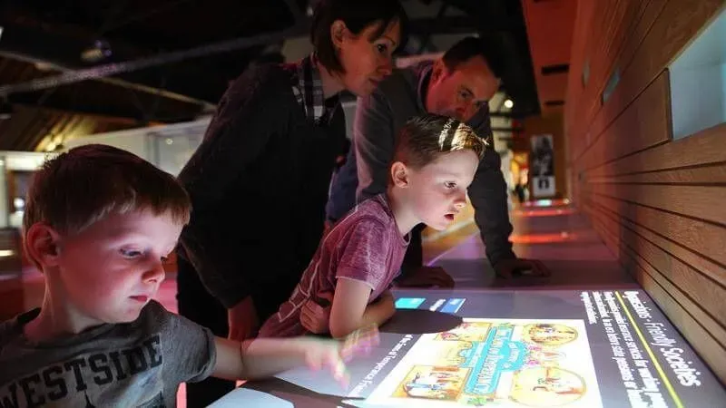 Kids looking at the interactive touch screens at the National Waterfront Museum.