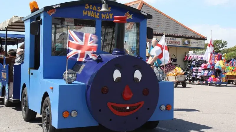The miniature Promenade Railway at Bognor Regis Beach, a blue train with a silly face painted on.