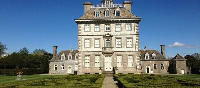 The exterior of Ashdown House in front of green lawns on a sunny day.