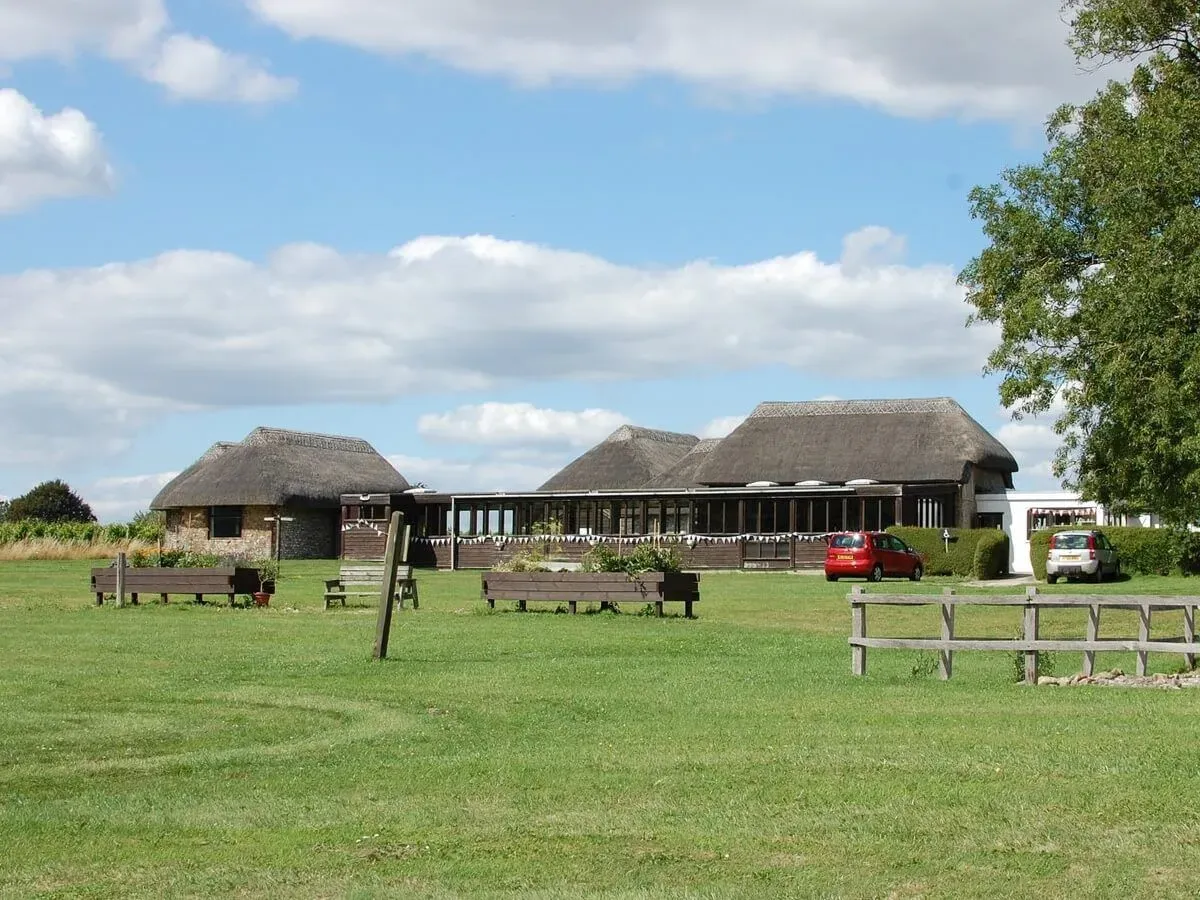 Thatched houses protecting the villa at Bignor Roman Villa & Museum.