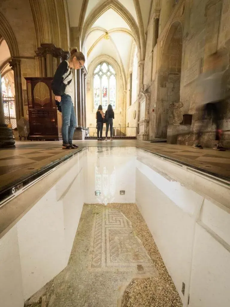 A visitor looking at some of the ancient remains on the floor of Chichester Cathedral.