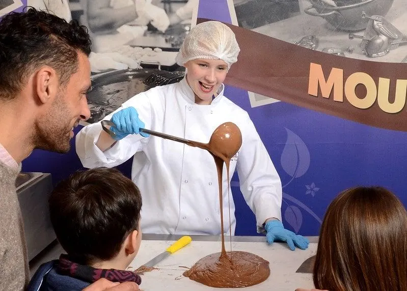 A chocolatier making chocolate in front of a family at Cadbury World.