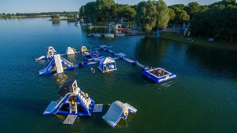 Aerial view of Aqua Park Rutland with inflatables and lake.