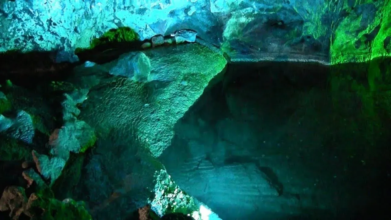 Green and blue lights on the rocks at Wookey Hole Caves.