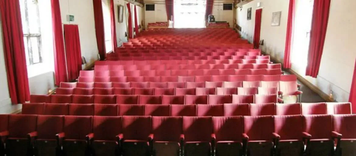 An inside view of the theatre at St George's Guildhall with lots of red chairs.