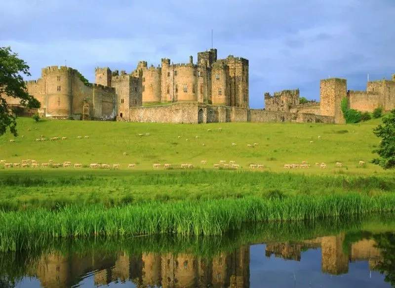 The Castle Exterior from the River Aln, reflected in its waters.