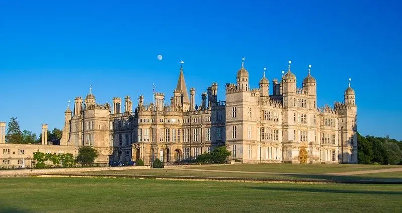 Burghley House and greenery in front of building exterior.