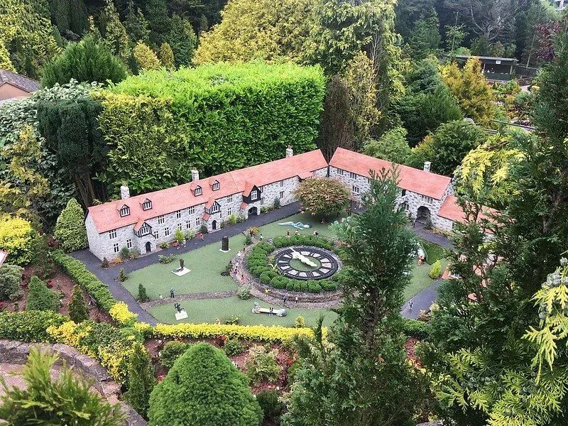Babbacombe Model Village stately home, surrounded by trees.