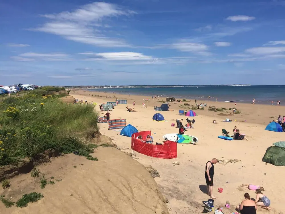 A view from the sand dunes at Fraisthorpe Beach of people sunbathing on a sunny day.