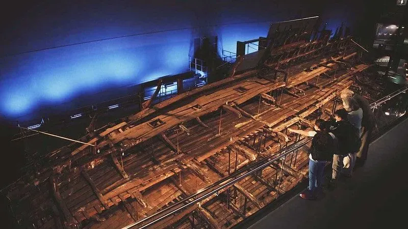 People looking at the shipwreck remains in The Mary Rose museum.