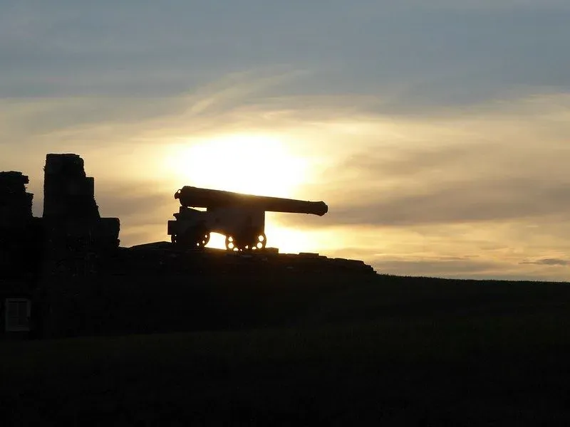 Pendennis Castle Tudor gun is in shadows as sun sets.