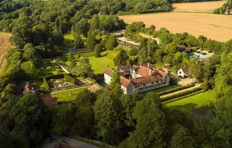 Aerial view of Ightham Mote with greenery and trees surrounding house.