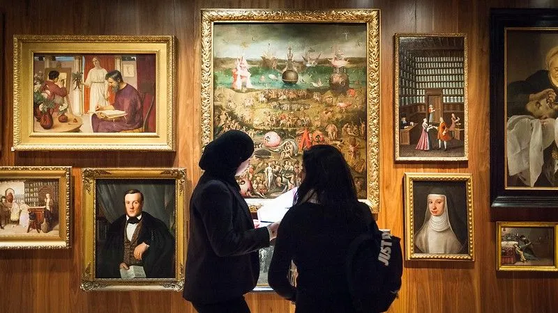 Two women looking at art in frames at the Wellcome Collection.