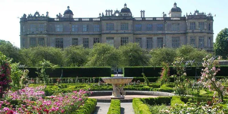 The grand Longleat House set behind beautifully arranged multicoloured garden flower beds
