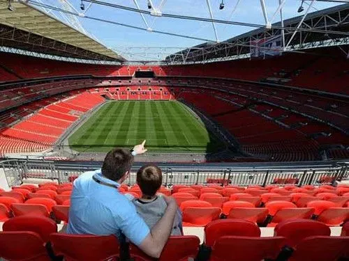 Family overlooking empty Wembley Stadium.