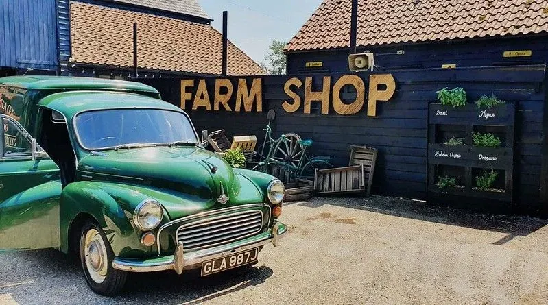 Old fashioned car in front of farm shop.