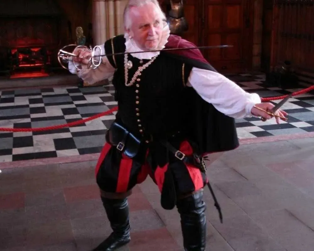 An actor portrays James Hepburn, holding a sword and dressed in historical clothing.