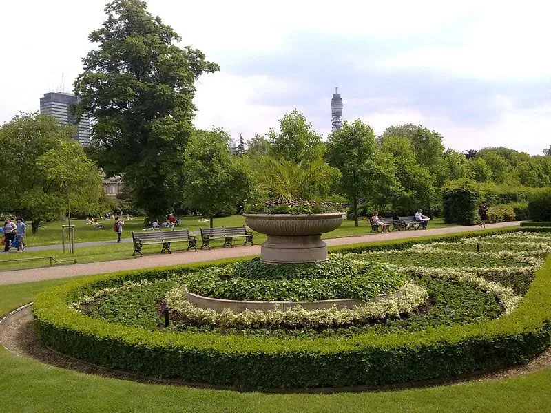 Garden feature of a circular topiary surrounding a stone fountain.