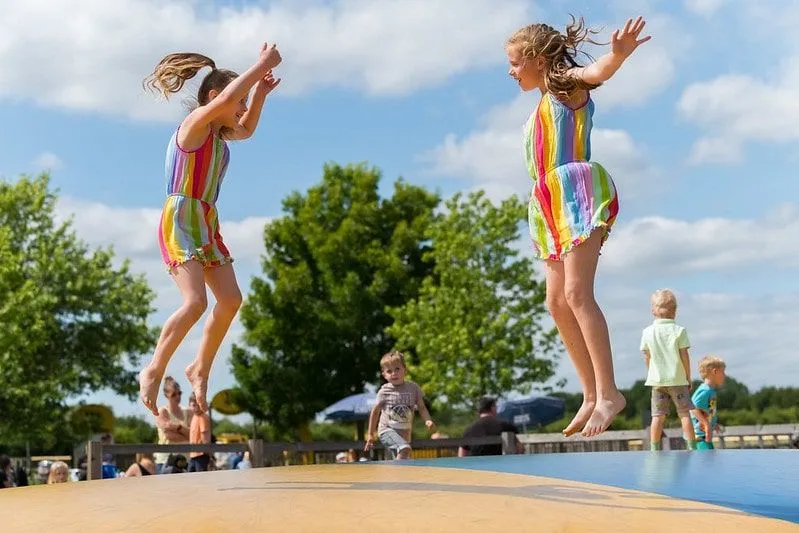 Two girls wearing matching colourful outfits happy and jumping. 