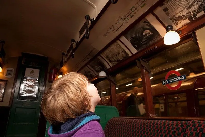 Boy looking at a display in an old train at the London Transport Museum.