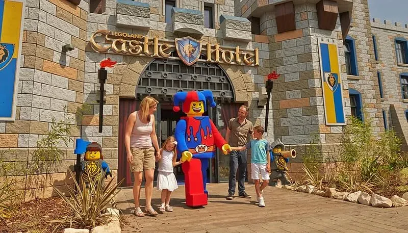 Family of four stood with a costumed Lego jester outside the Legoland Castle Hotel.