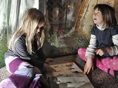 Two young girls sat on the floor learning at the Museum of London.